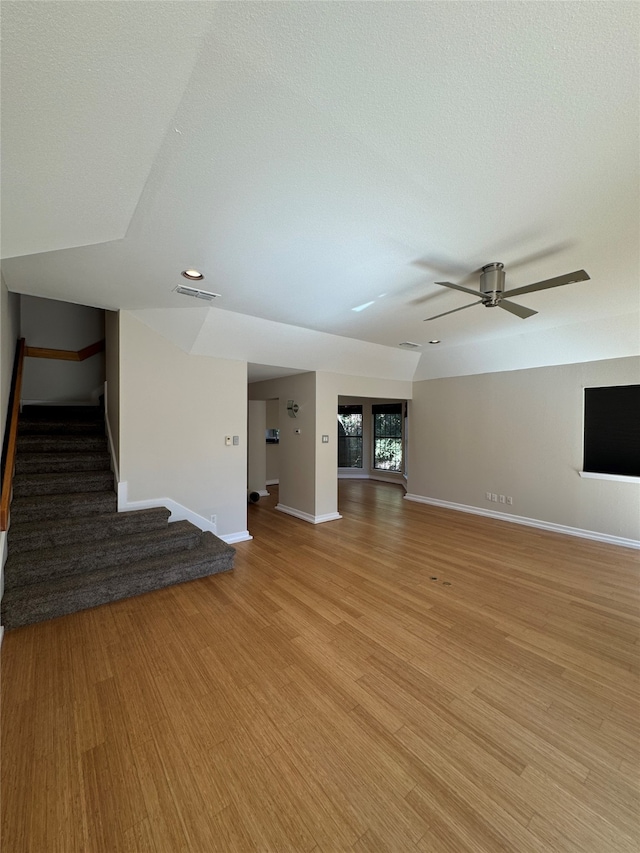 unfurnished living room with light hardwood / wood-style floors, a textured ceiling, and ceiling fan