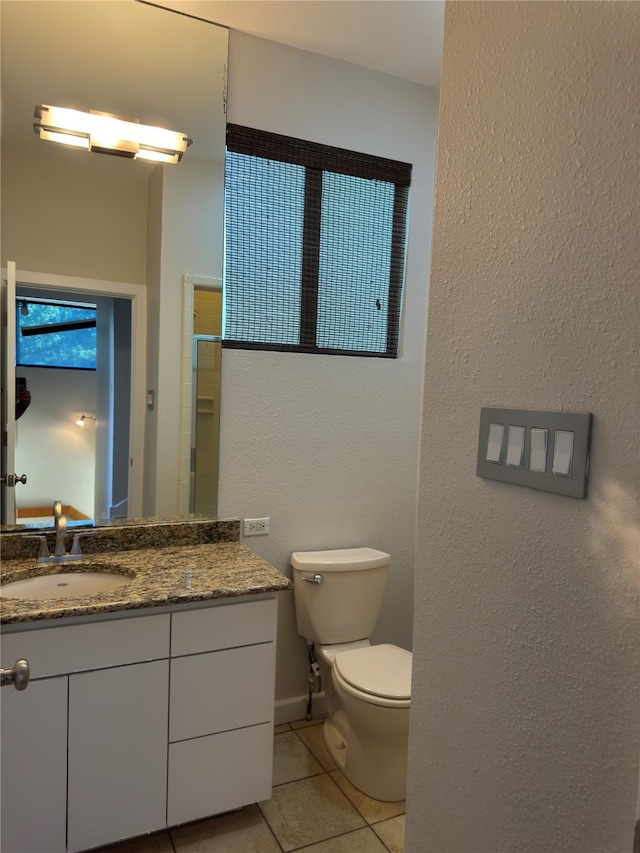 bathroom featuring vanity, toilet, and tile patterned flooring