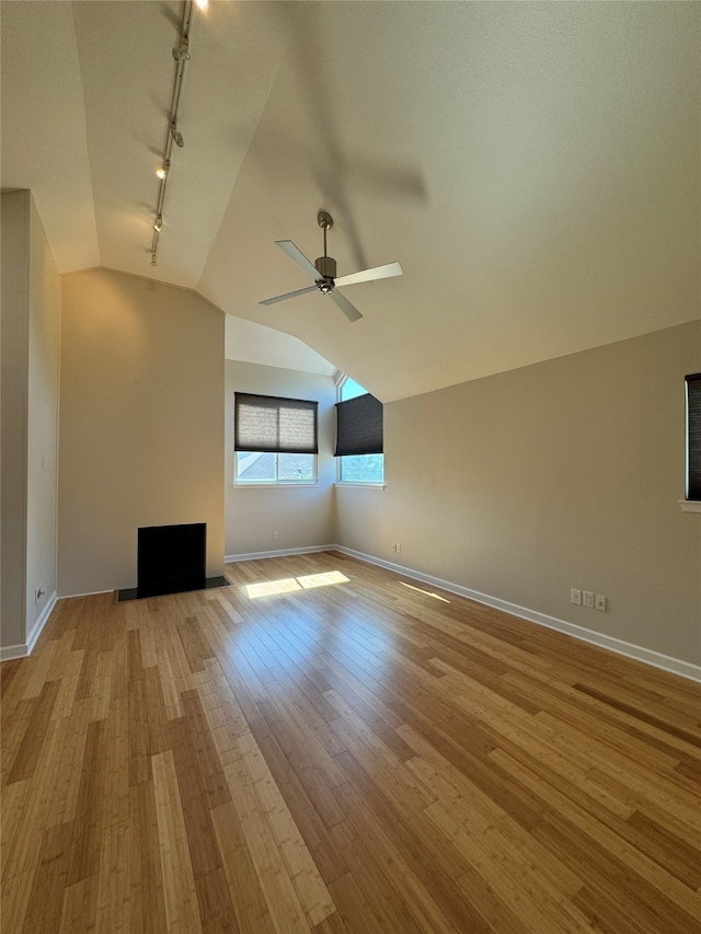 unfurnished living room with light hardwood / wood-style floors, lofted ceiling, ceiling fan, and rail lighting