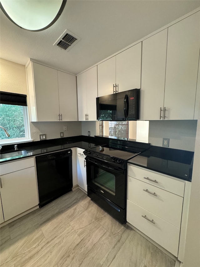 kitchen with white cabinetry, black appliances, and sink