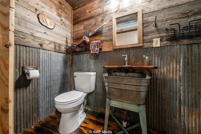 half bathroom featuring wood walls and toilet