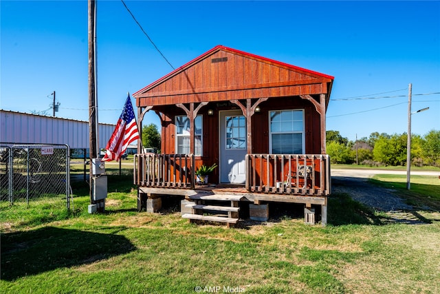 exterior space with covered porch, fence, and a front yard