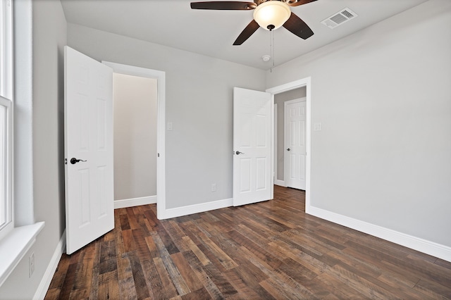 unfurnished bedroom featuring dark wood-type flooring and ceiling fan