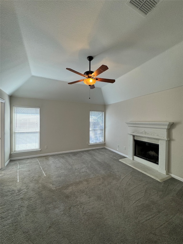 unfurnished living room with vaulted ceiling, carpet flooring, a healthy amount of sunlight, and ceiling fan