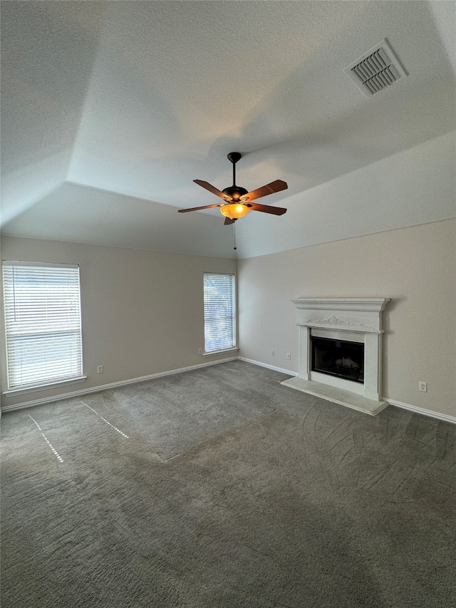 unfurnished living room featuring lofted ceiling, carpet floors, a healthy amount of sunlight, and ceiling fan