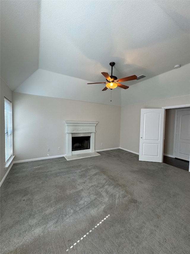 unfurnished living room featuring dark colored carpet, lofted ceiling, a textured ceiling, and ceiling fan