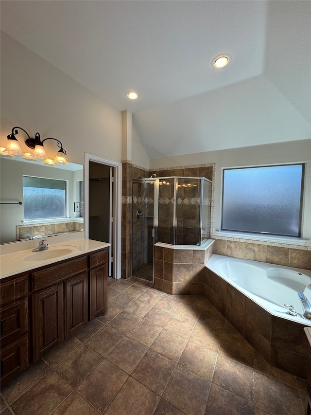 bathroom with vanity, lofted ceiling, and separate shower and tub