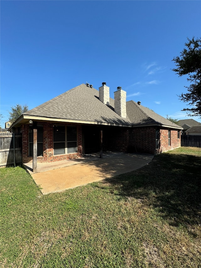 rear view of property with a yard and a patio area