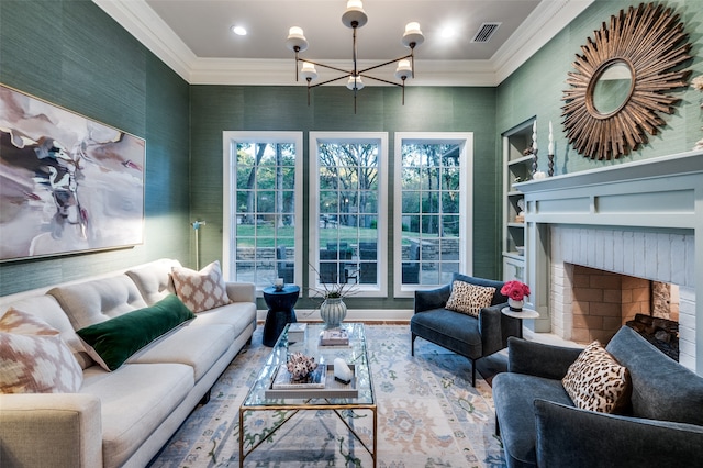 living room featuring built in shelves, crown molding, a fireplace, and a chandelier