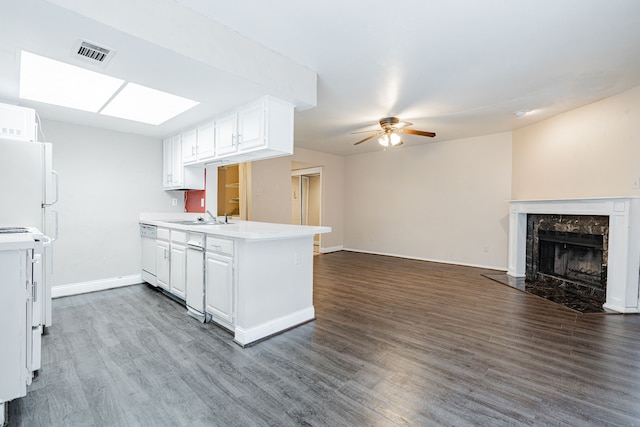 kitchen with kitchen peninsula, sink, dark hardwood / wood-style flooring, white cabinetry, and ceiling fan