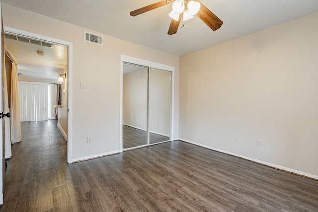 unfurnished bedroom with ceiling fan, a closet, and dark hardwood / wood-style flooring