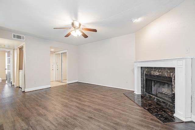 unfurnished living room featuring dark wood-type flooring, a fireplace, and ceiling fan