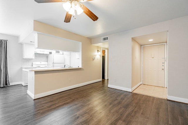 unfurnished living room featuring dark wood-type flooring and ceiling fan