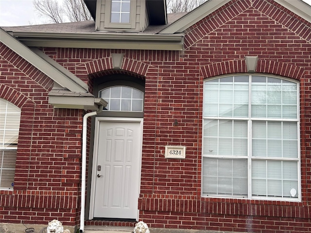 view of exterior entry featuring brick siding