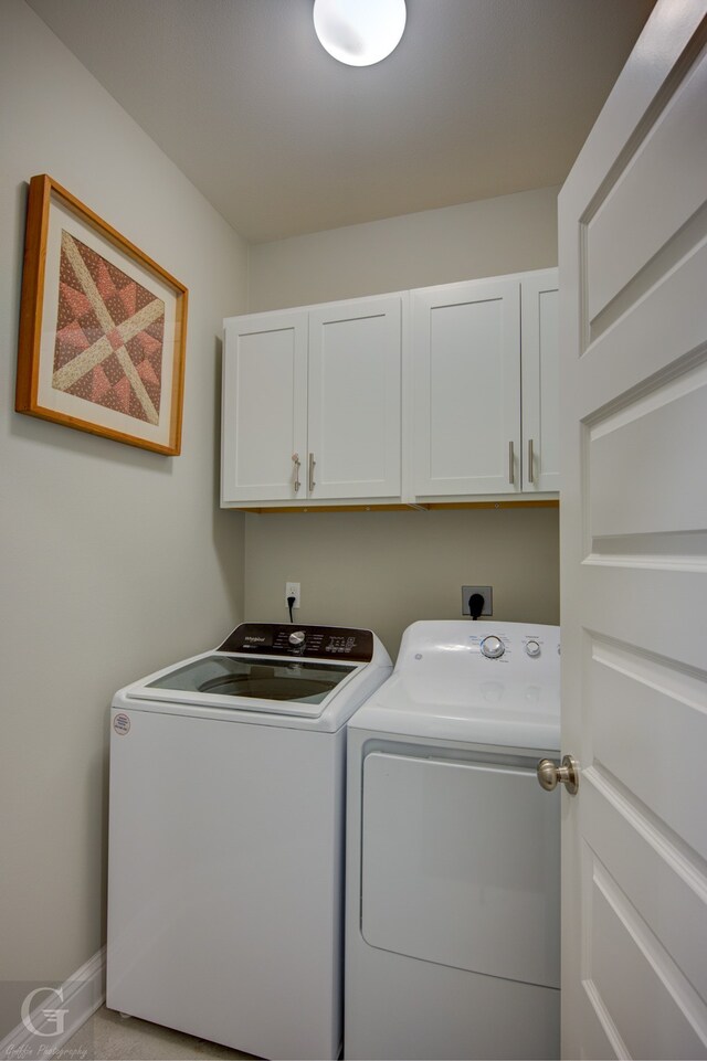 laundry area with cabinets and washing machine and clothes dryer