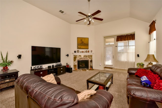 living room featuring ceiling fan, a stone fireplace, lofted ceiling, and light colored carpet