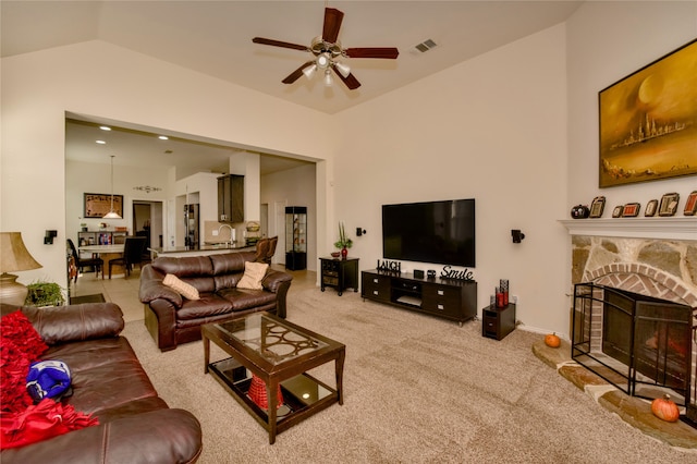 living room with sink, vaulted ceiling, light colored carpet, a fireplace, and ceiling fan