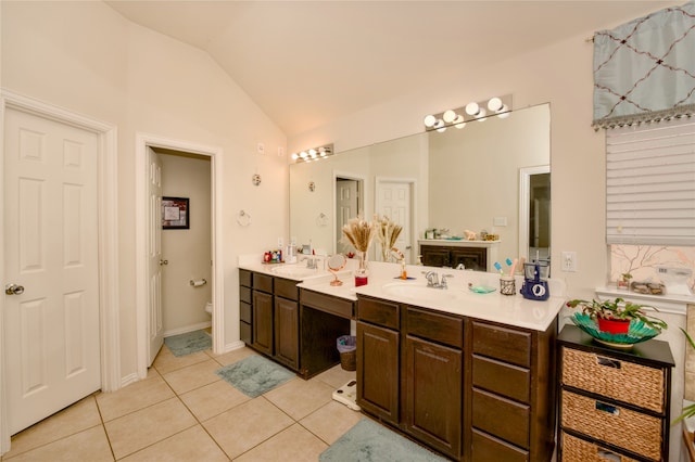 bathroom featuring vanity, lofted ceiling, toilet, and tile patterned flooring