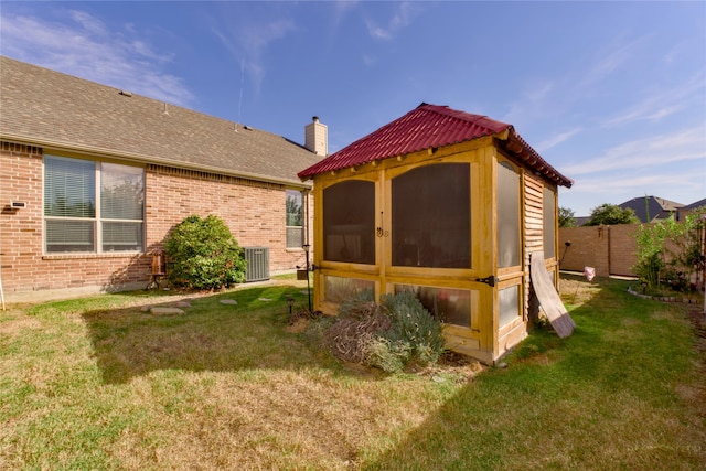 back of house with a yard, central AC unit, and an outdoor structure