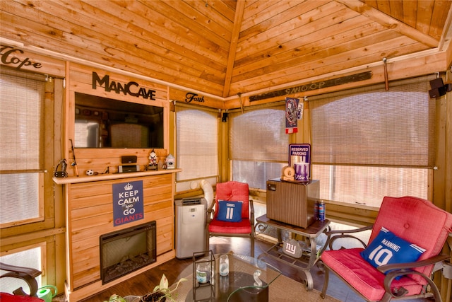 sitting room with wood walls, lofted ceiling, and wooden ceiling