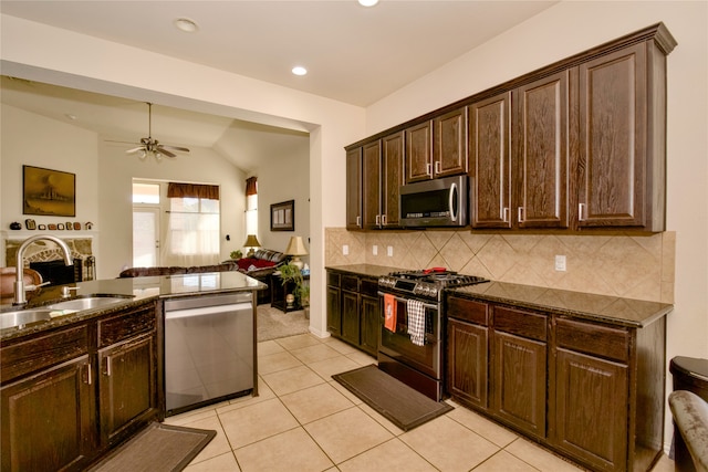 kitchen with dark brown cabinets, stainless steel appliances, sink, and vaulted ceiling