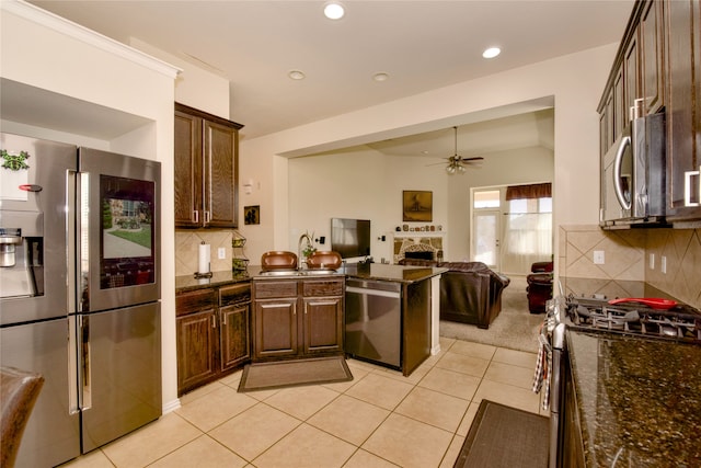 kitchen with ceiling fan, stainless steel appliances, tasteful backsplash, and light tile patterned floors