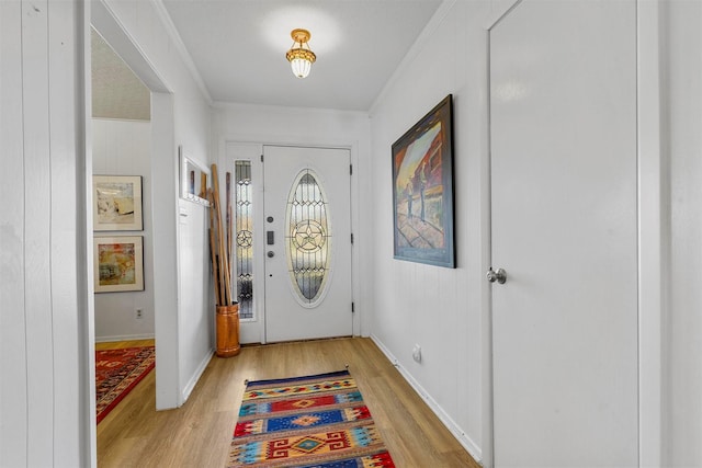 doorway to outside featuring light hardwood / wood-style floors and crown molding