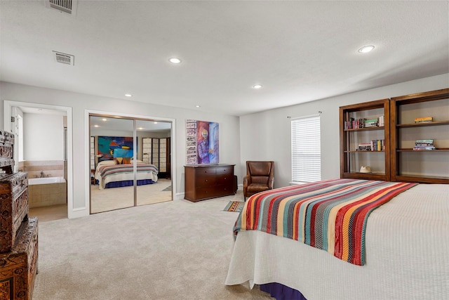 bedroom featuring connected bathroom and light colored carpet