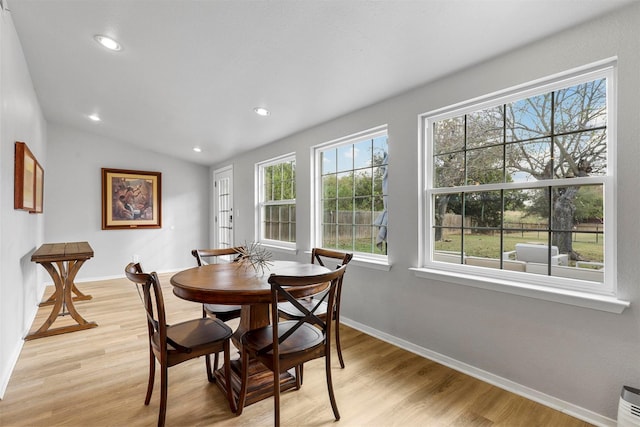 dining area featuring light hardwood / wood-style floors and vaulted ceiling