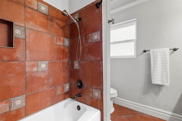 bathroom with tiled shower / bath combo and toilet