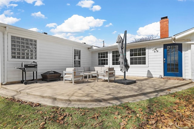 rear view of house featuring a patio area and an outdoor living space with a fire pit