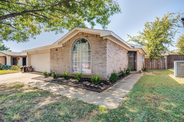 ranch-style house with a front lawn, central AC, and a garage