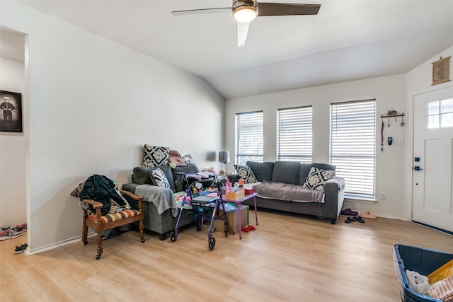 living room featuring light hardwood / wood-style floors, vaulted ceiling, and ceiling fan