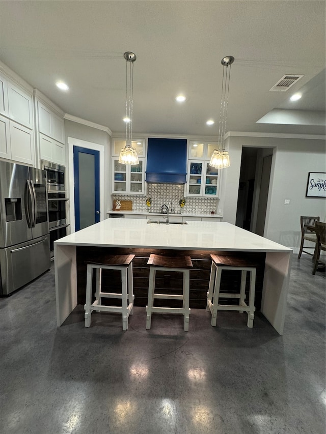 kitchen with a large island, decorative backsplash, hanging light fixtures, a breakfast bar area, and appliances with stainless steel finishes