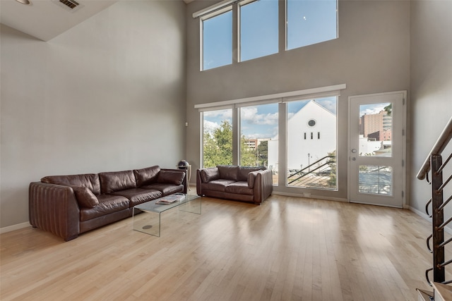 living room featuring a high ceiling and light wood-type flooring