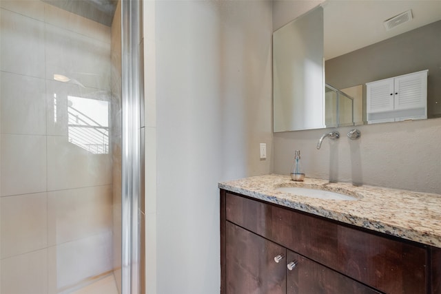 bathroom featuring vanity and a shower with shower door