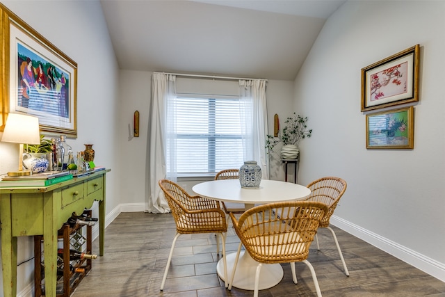 dining space featuring lofted ceiling and dark wood-type flooring