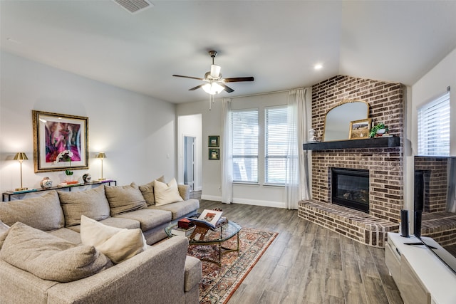 living room featuring hardwood / wood-style flooring, lofted ceiling, a wealth of natural light, and a fireplace