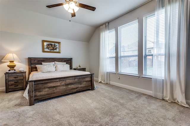 bedroom featuring lofted ceiling, light carpet, multiple windows, and ceiling fan