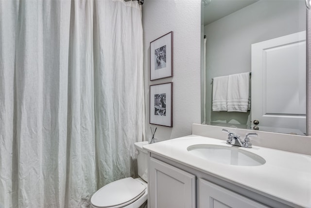 bathroom featuring vanity, walk in shower, and toilet