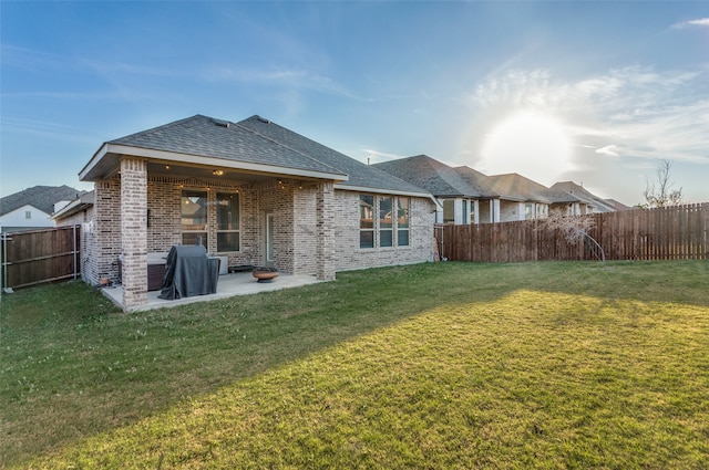 rear view of house with a patio and a lawn