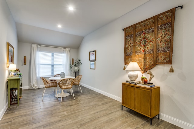 dining room with lofted ceiling and light wood-type flooring