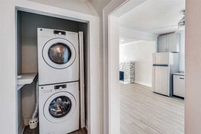 laundry area featuring stacked washer and dryer and light wood-type flooring