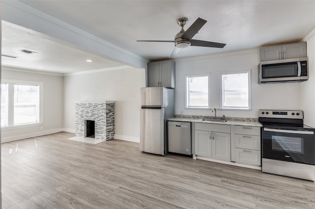 kitchen featuring gray cabinetry, light hardwood / wood-style floors, appliances with stainless steel finishes, and a wealth of natural light