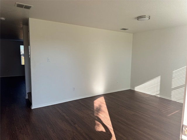 unfurnished room with dark hardwood / wood-style flooring