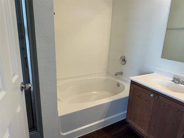 bathroom with vanity, wood-type flooring, and a bathing tub