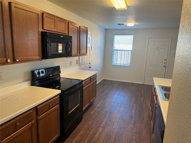 kitchen with a textured ceiling, black appliances, sink, and dark hardwood / wood-style floors