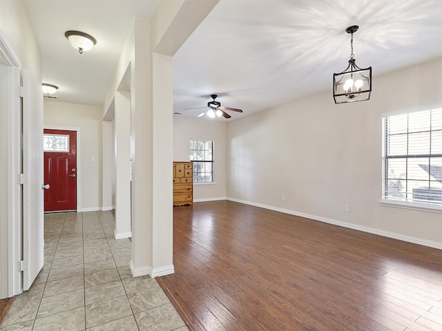 interior space featuring ceiling fan with notable chandelier and hardwood / wood-style floors