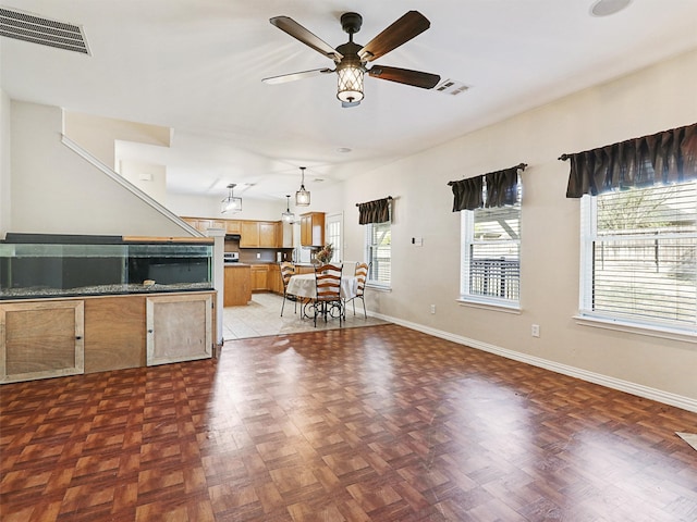 unfurnished living room featuring dark parquet flooring and ceiling fan