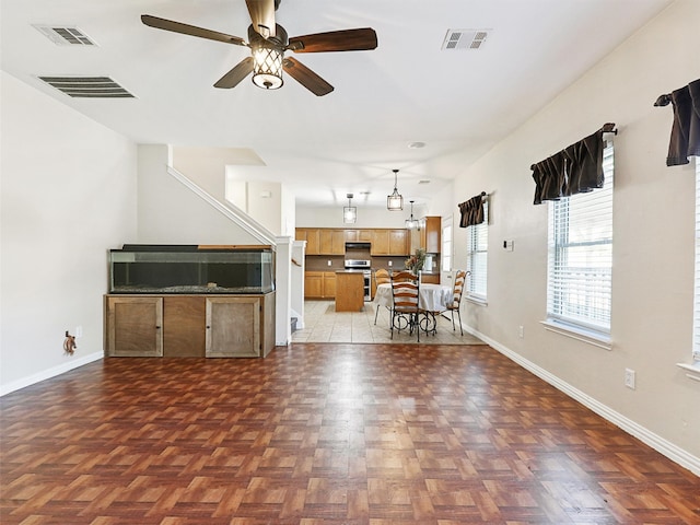 unfurnished living room with dark parquet floors and ceiling fan